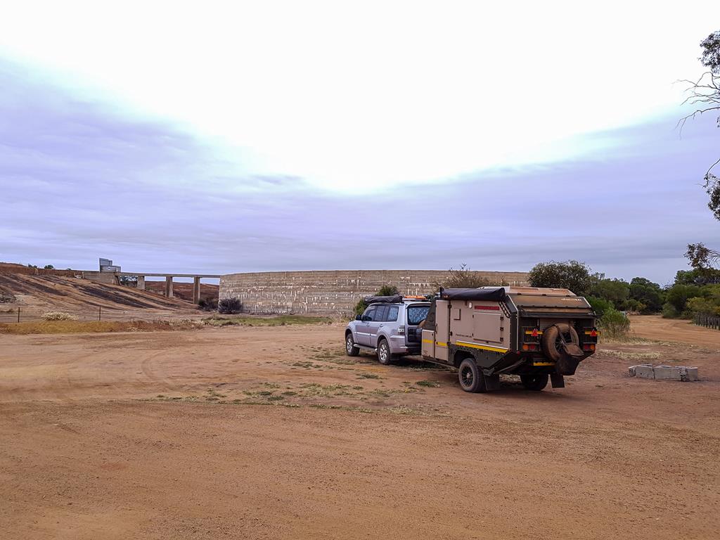 A vehicle and caravan parked in front of Beringbooding Rock in the Wheatbelt 