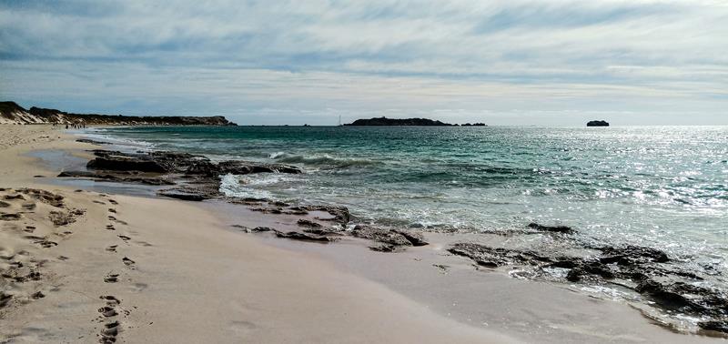Footprints on the rocky beach, near water