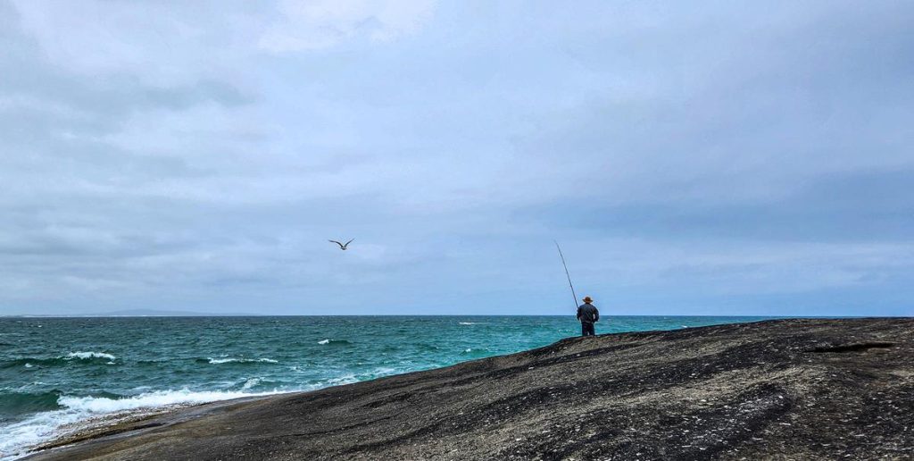 Man fishing off the rock at Cape Arid