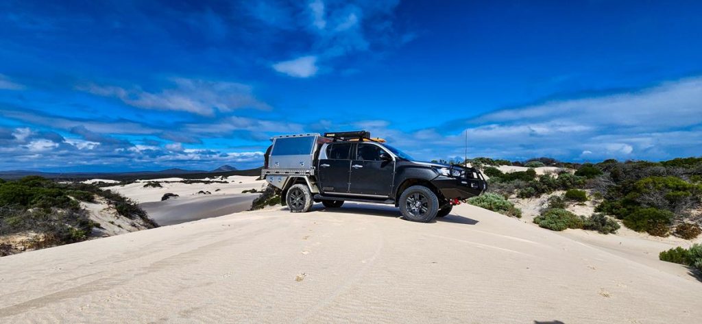 A vehicle on top of a sandy hill at Hamersley dunes