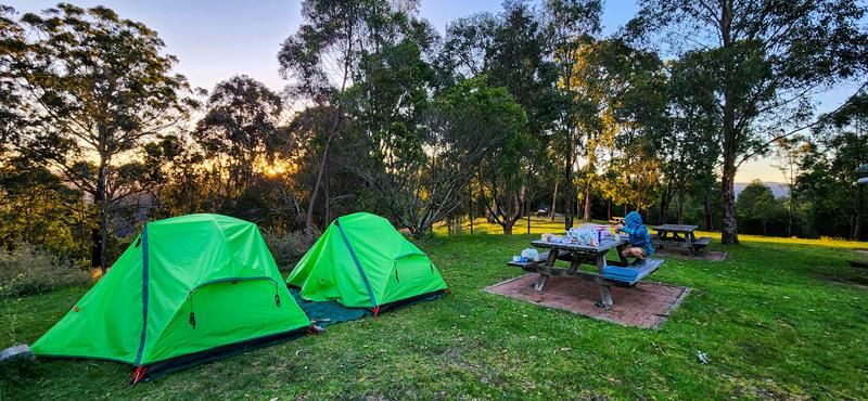Two tents and a child sitting at the table at Dunphys camgpround