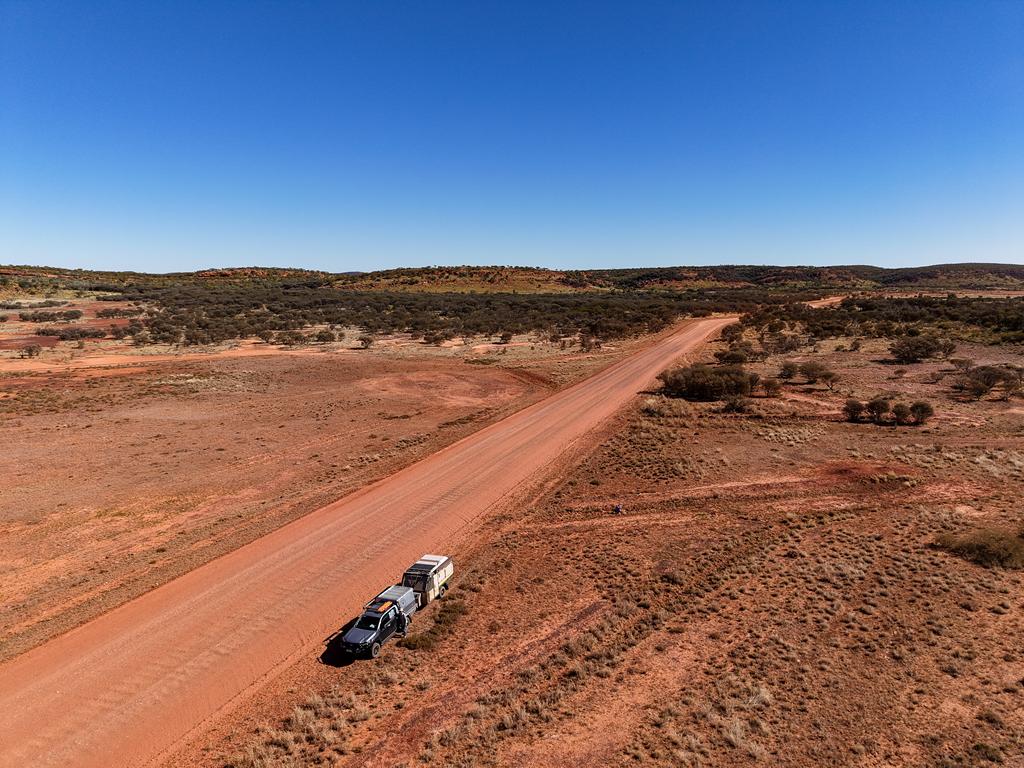 A vehicle with a small caravan stopped on the side of Meerenie Loop